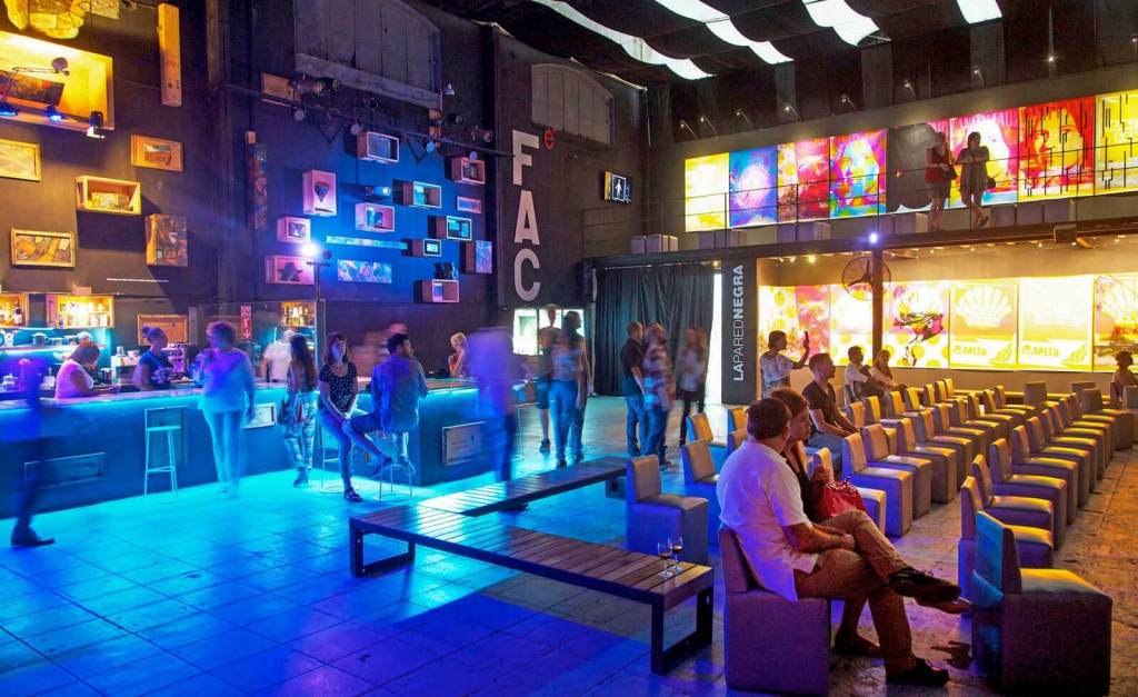 The unique industrial interior of Fábrica de Arte Cubano, showcasing modern art installations and a lively crowd.