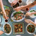 Overhead shot of a Northern Thai (Lanna) shared meal in Chiang Mai—sticky rice bowls, nam prik dips and herb-packed curries.